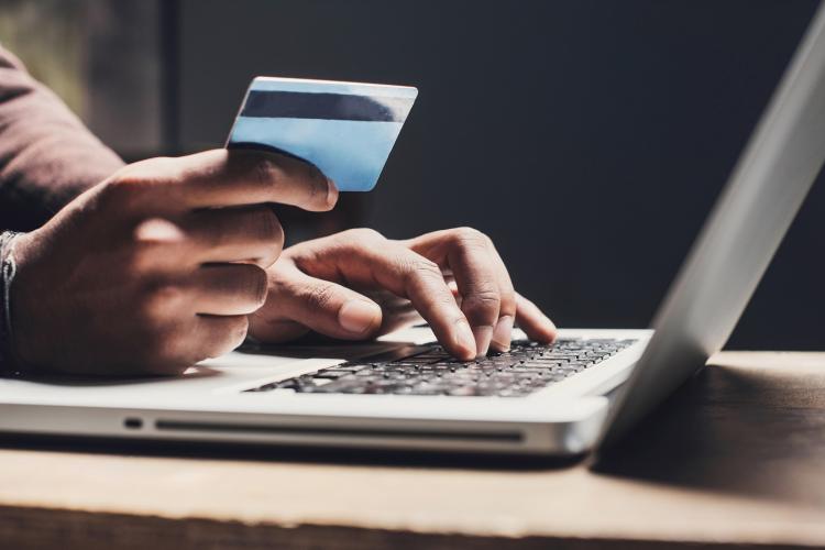 person entering credit card details on computer